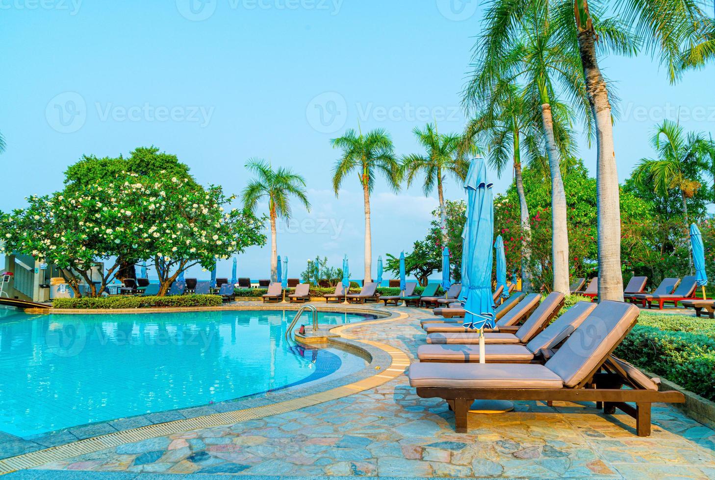 sedie piscine e ombrelloni intorno alla piscina con palme da cocco - vacanze e concetto di vacanza vacation foto