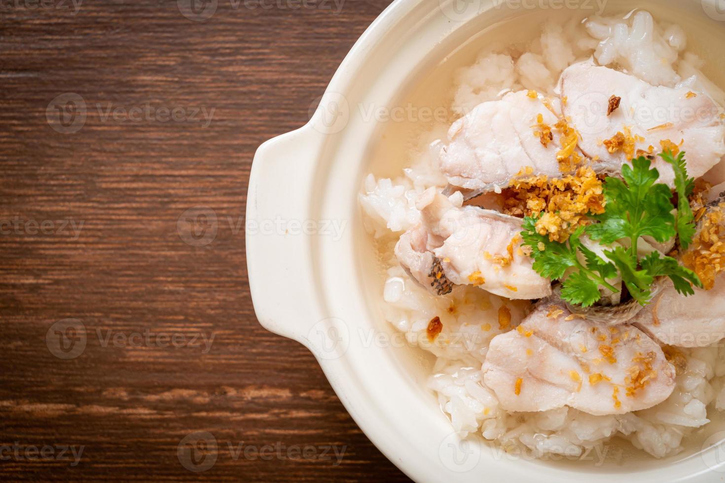 zuppa di porridge o riso bollito con scodella di pesce foto