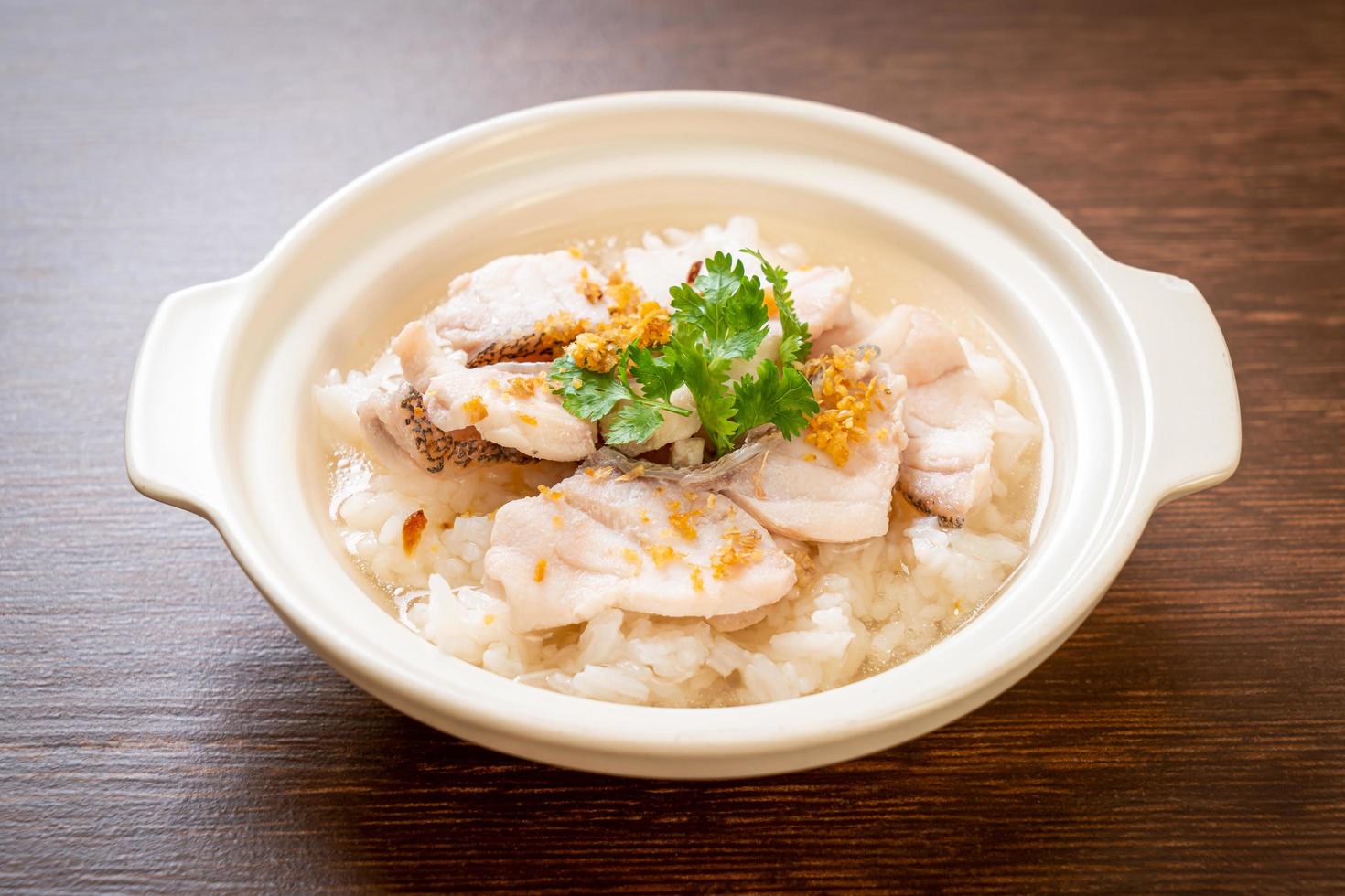 zuppa di porridge o riso bollito con scodella di pesce foto