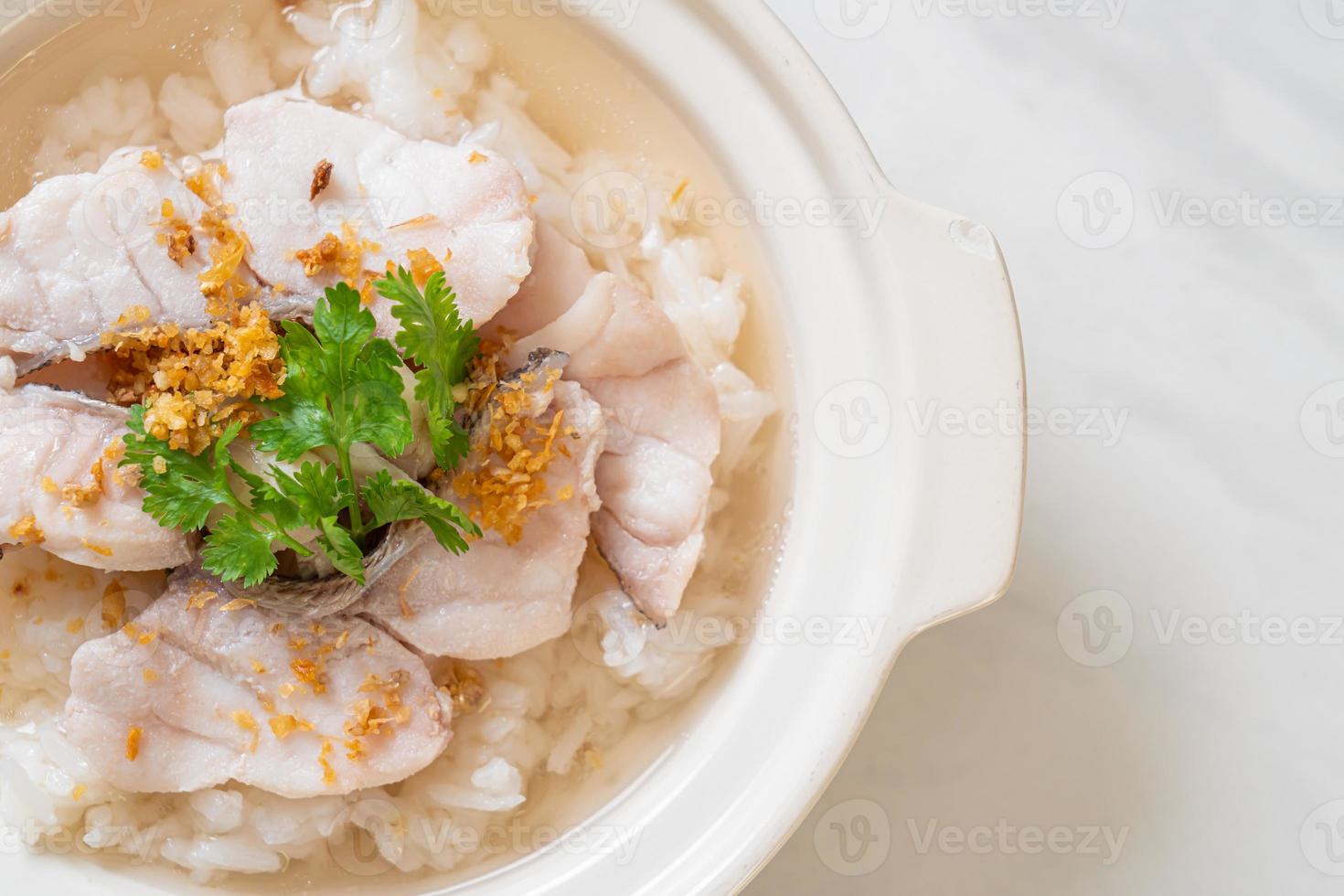 zuppa di porridge o riso bollito con scodella di pesce foto