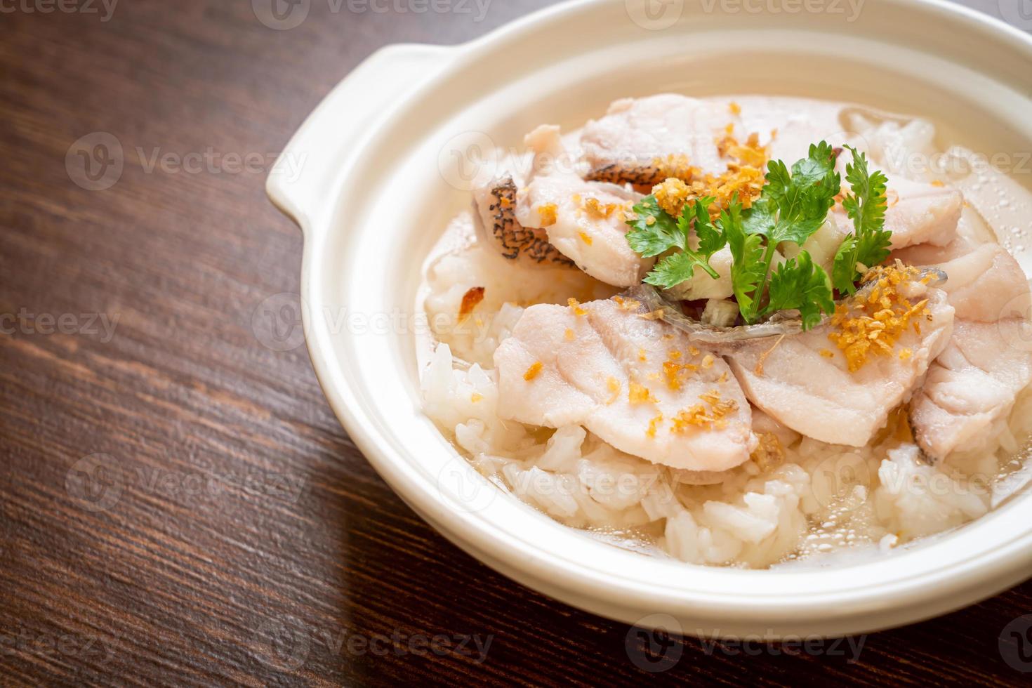 zuppa di porridge o riso bollito con scodella di pesce foto