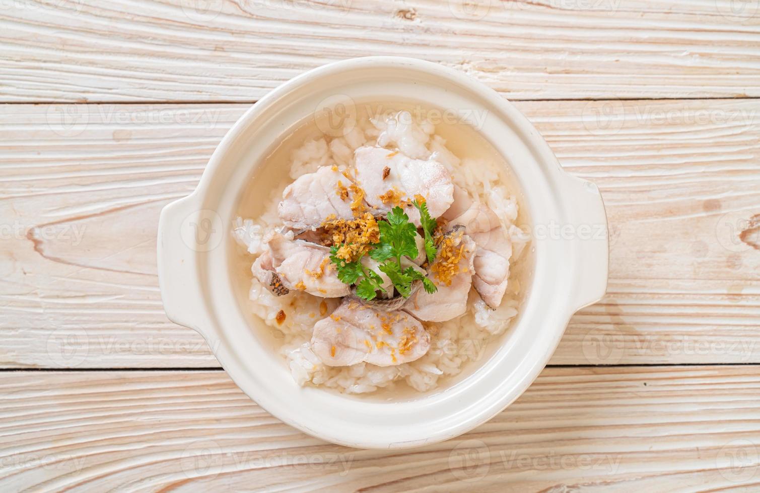 zuppa di porridge o riso bollito con scodella di pesce foto