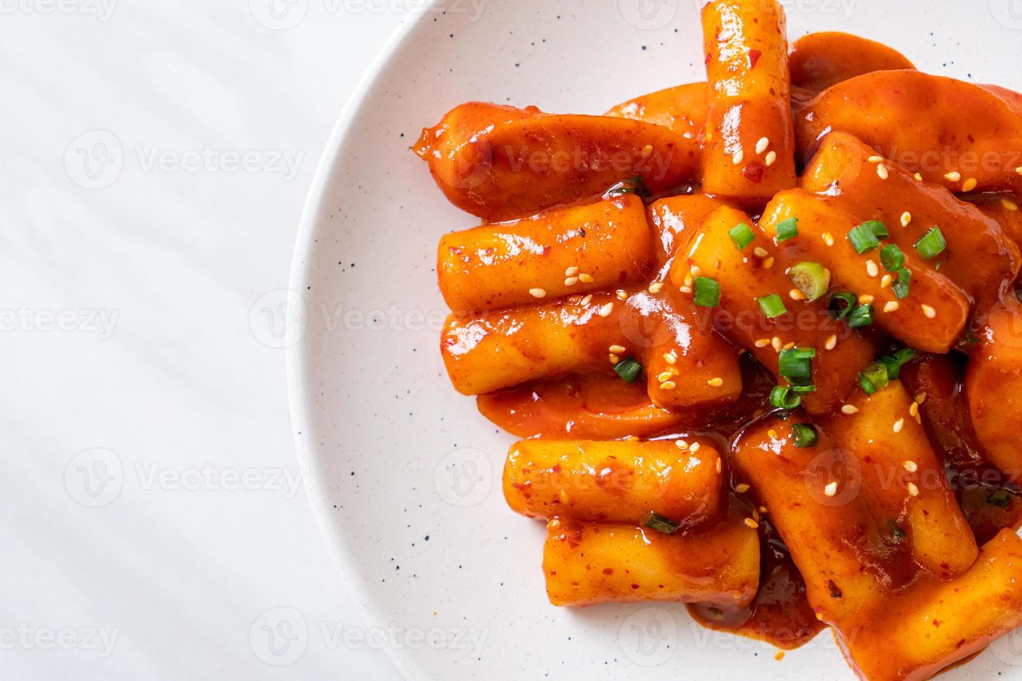 Stecco di torta di riso coreano con salsiccia in salsa piccante - tteokbokki foto