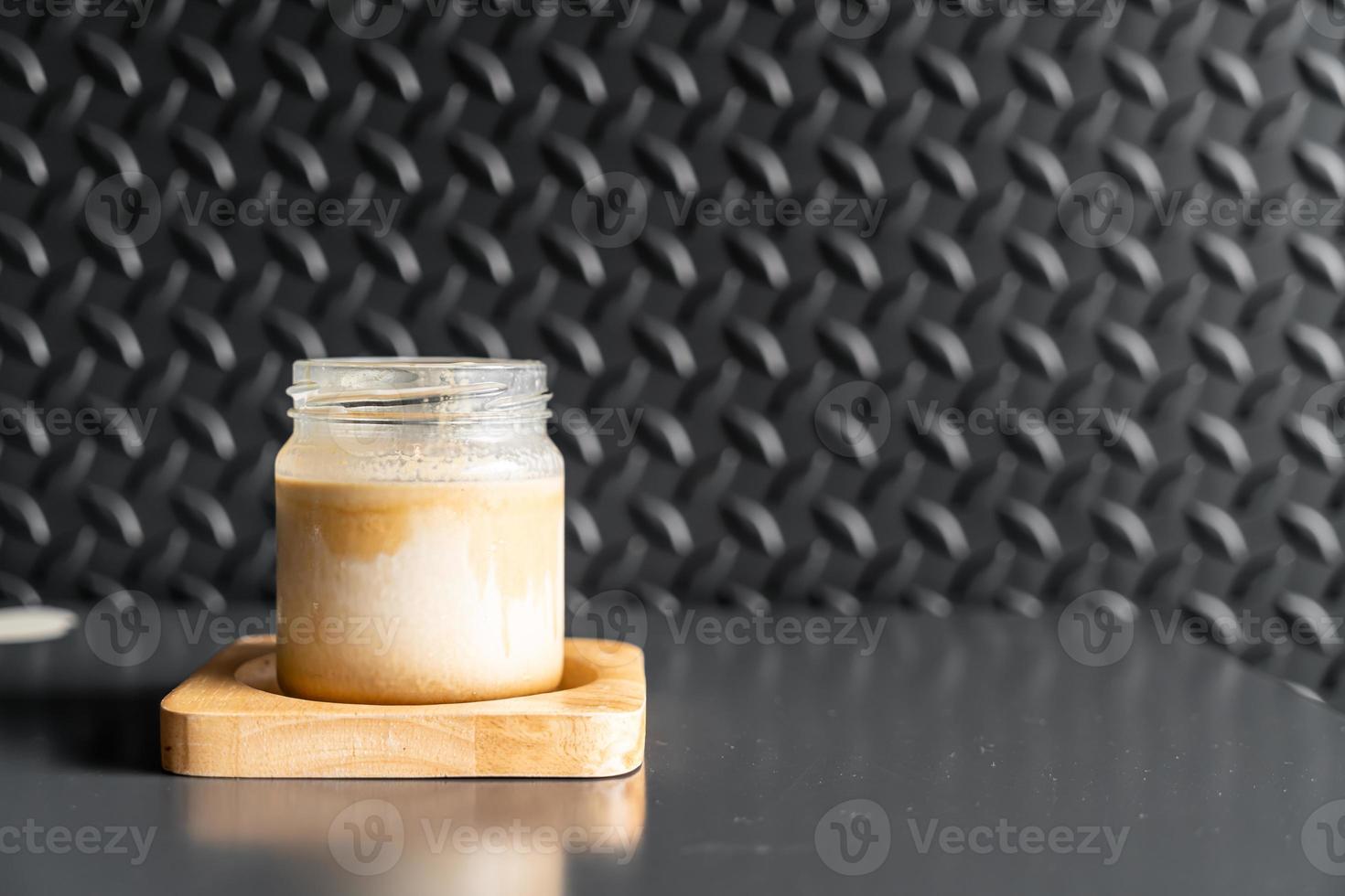 un bicchiere di caffè espresso sparato su latte fresco freddo crea uno strato sfumato chiamato caffè sporco dirty foto