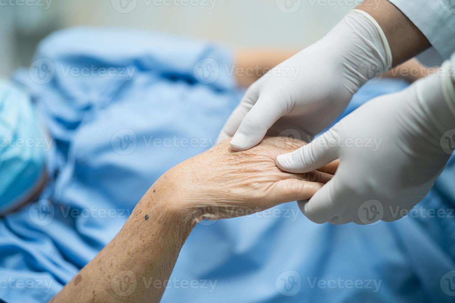 medico che tiene la mano di una paziente asiatica che indossa una maschera facciale per proteggere il coronavirus covid-19. foto