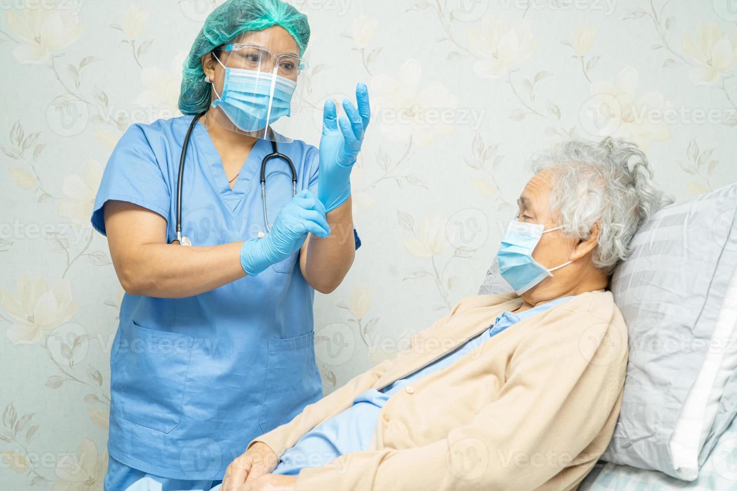 medico che utilizza lo stetoscopio per controllare la donna anziana asiatica anziana o anziana paziente che indossa una maschera facciale in ospedale per proteggere l'infezione covid-19 coronavirus. foto