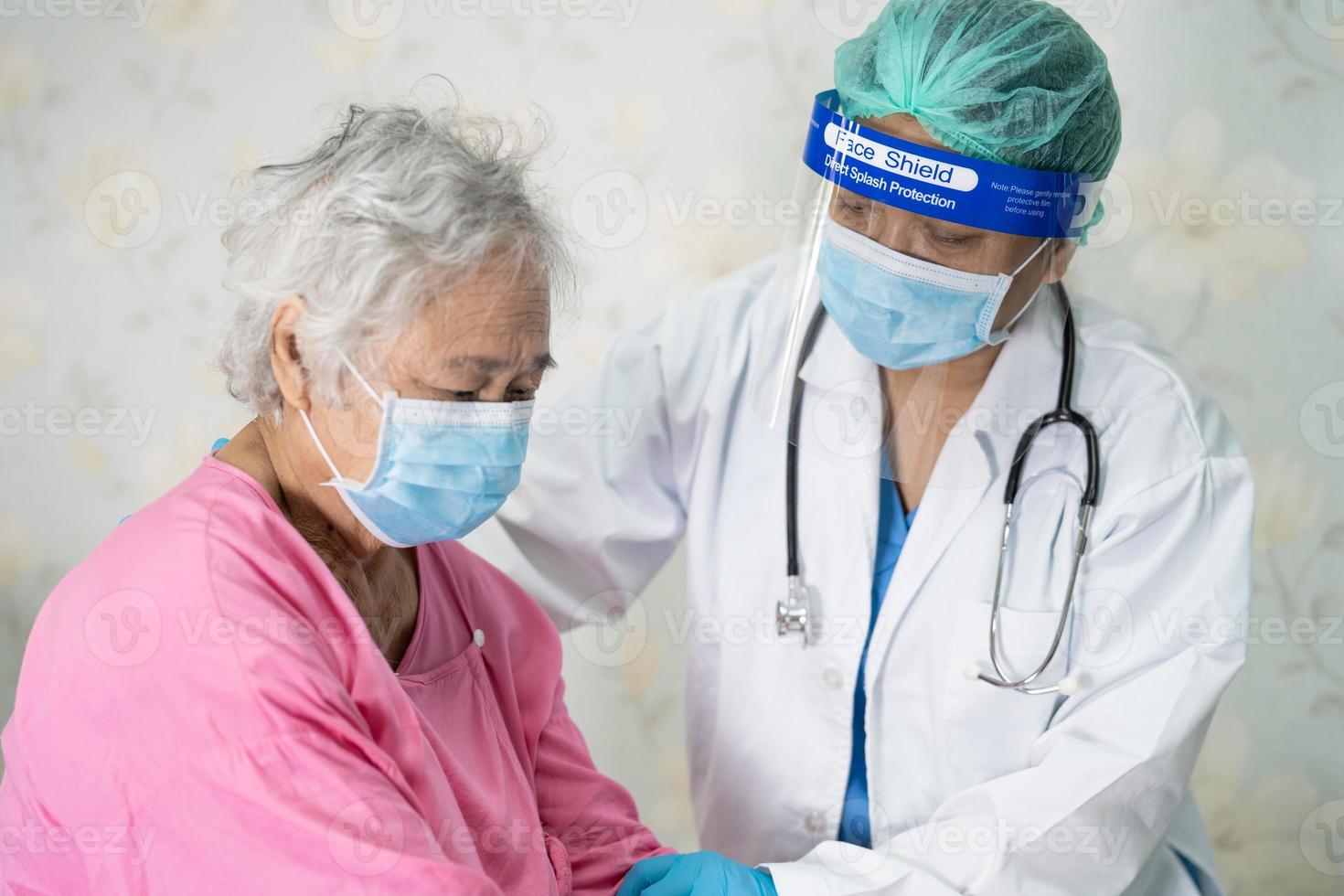 medico che controlla la donna anziana o anziana asiatica paziente che indossa una maschera facciale in ospedale per proteggere l'infezione covid-19 coronavirus. foto