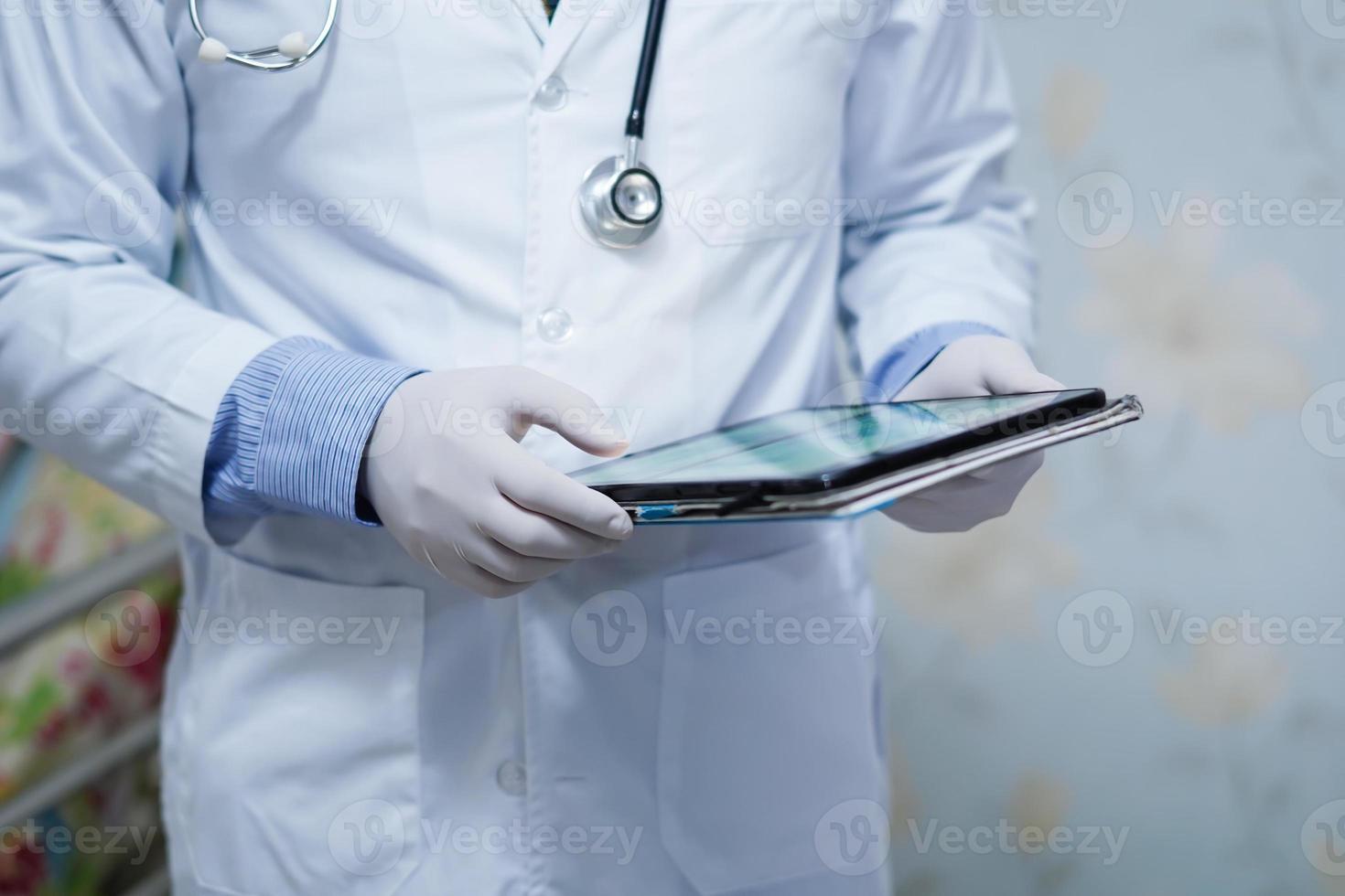 medico in possesso di tablet digitale per cercare i dati per il trattamento del paziente nel reparto infermieristico dell'ospedale foto