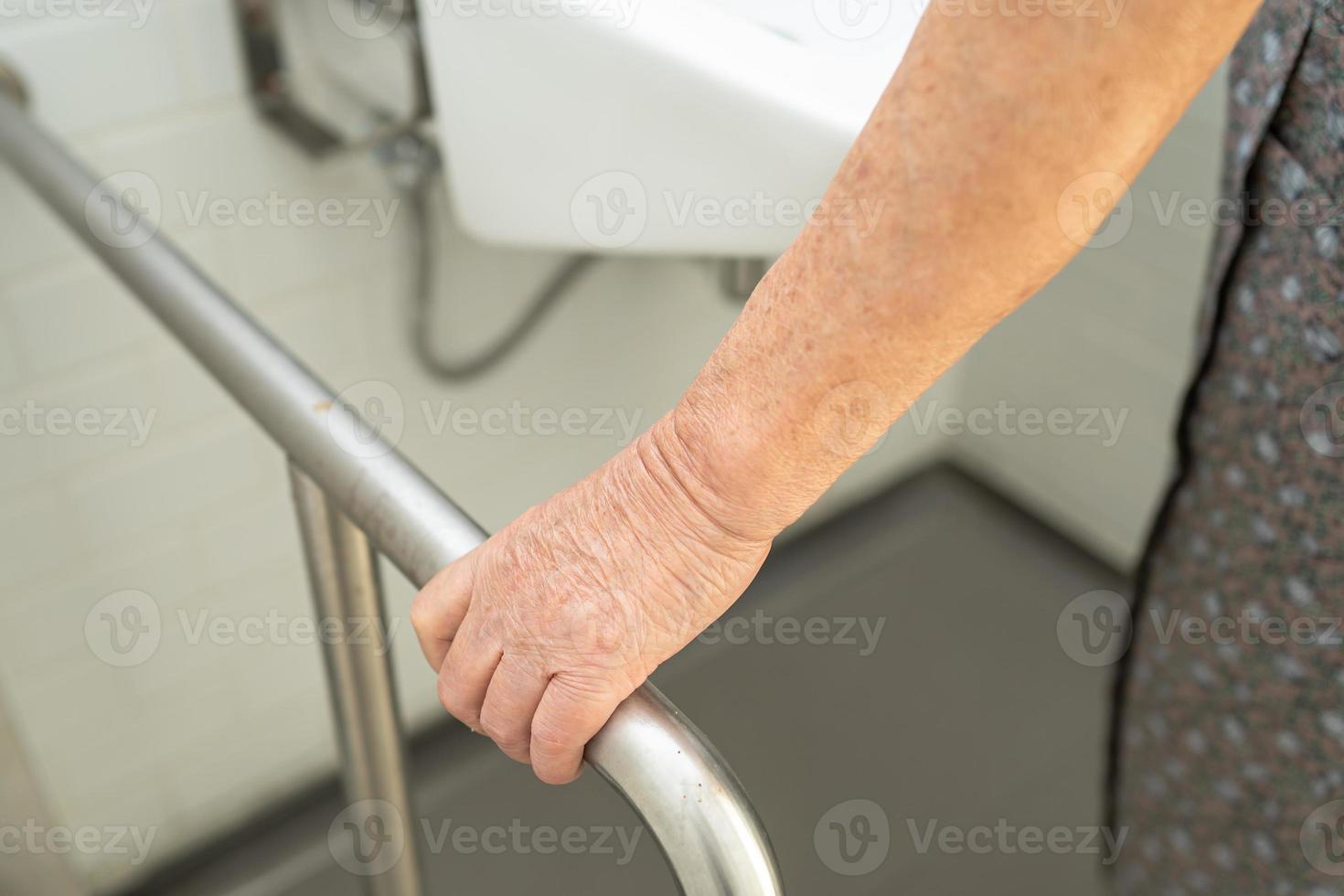 asiatico anziano o anziano signora anziana donna paziente uso toilette bagno maniglia sicurezza nel reparto infermieristico foto