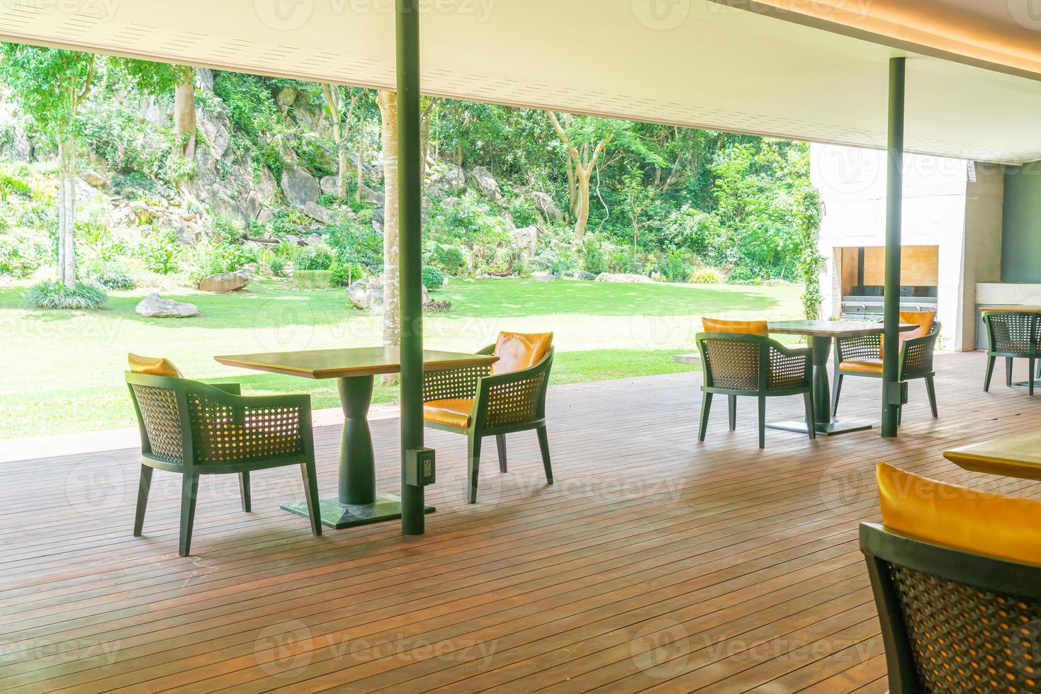 sedia da giardino e tavolo sul balcone con sfondo giardino foto