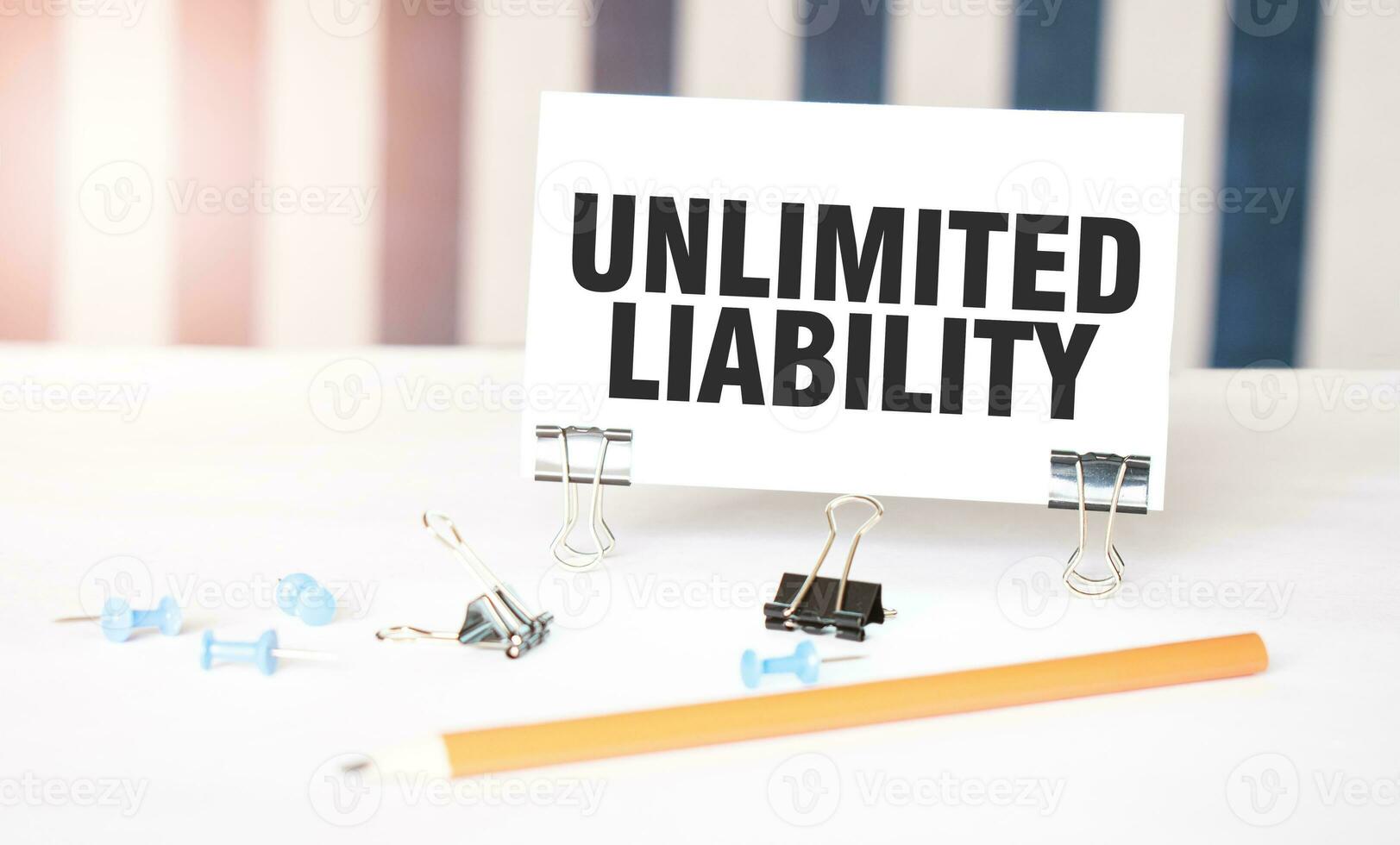 illimitato responsabilità cartello su carta su bianca scrivania con ufficio Strumenti. blu e bianca sfondo foto