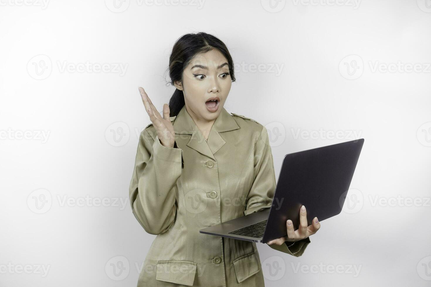 scioccato governo lavoratore donna Tenere sua il computer portatile con sua bocca largo aprire. pns indossare cachi uniforme. foto