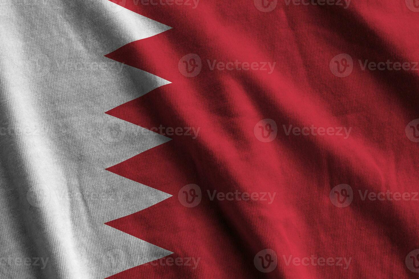 bahrain bandiera con grande pieghe agitando vicino su sotto il studio leggero al chiuso. il ufficiale simboli e colori nel bandiera foto