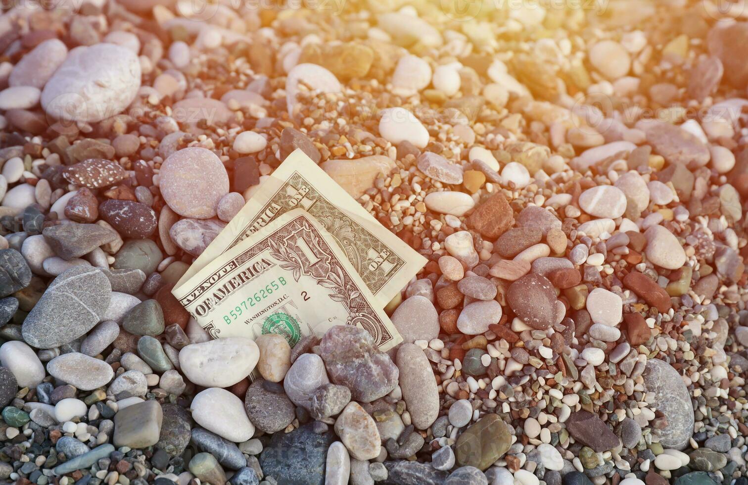 uno dollaro metà coperto con il giro rocce menzogna su spiaggia foto