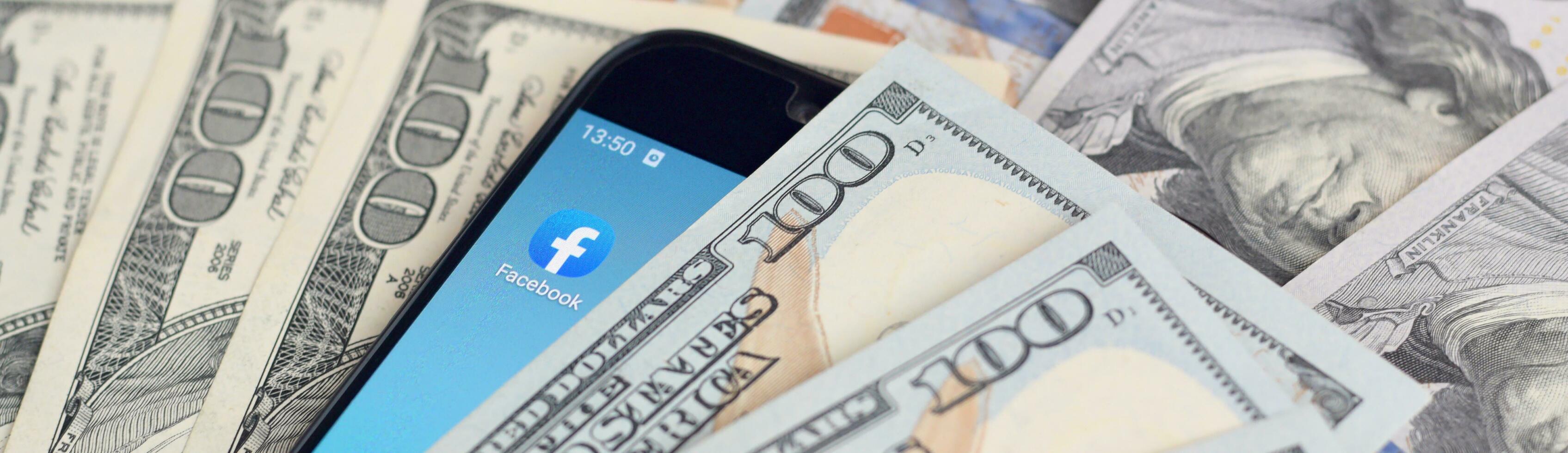 smartphone schermo con Facebook App e lotto di centinaio dollaro fatture. attività commerciale e sociale networking concetto foto