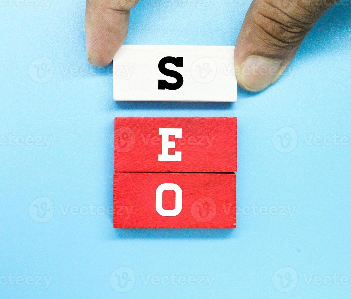 mano che tiene blocchi colorati con lettere seo foto