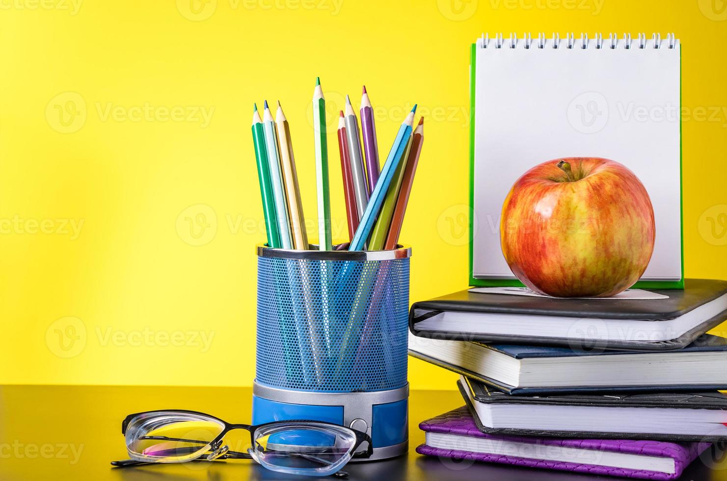 torna al concetto di scuola. materiale scolastico e libri su sfondo giallo. posto per il testo. foto