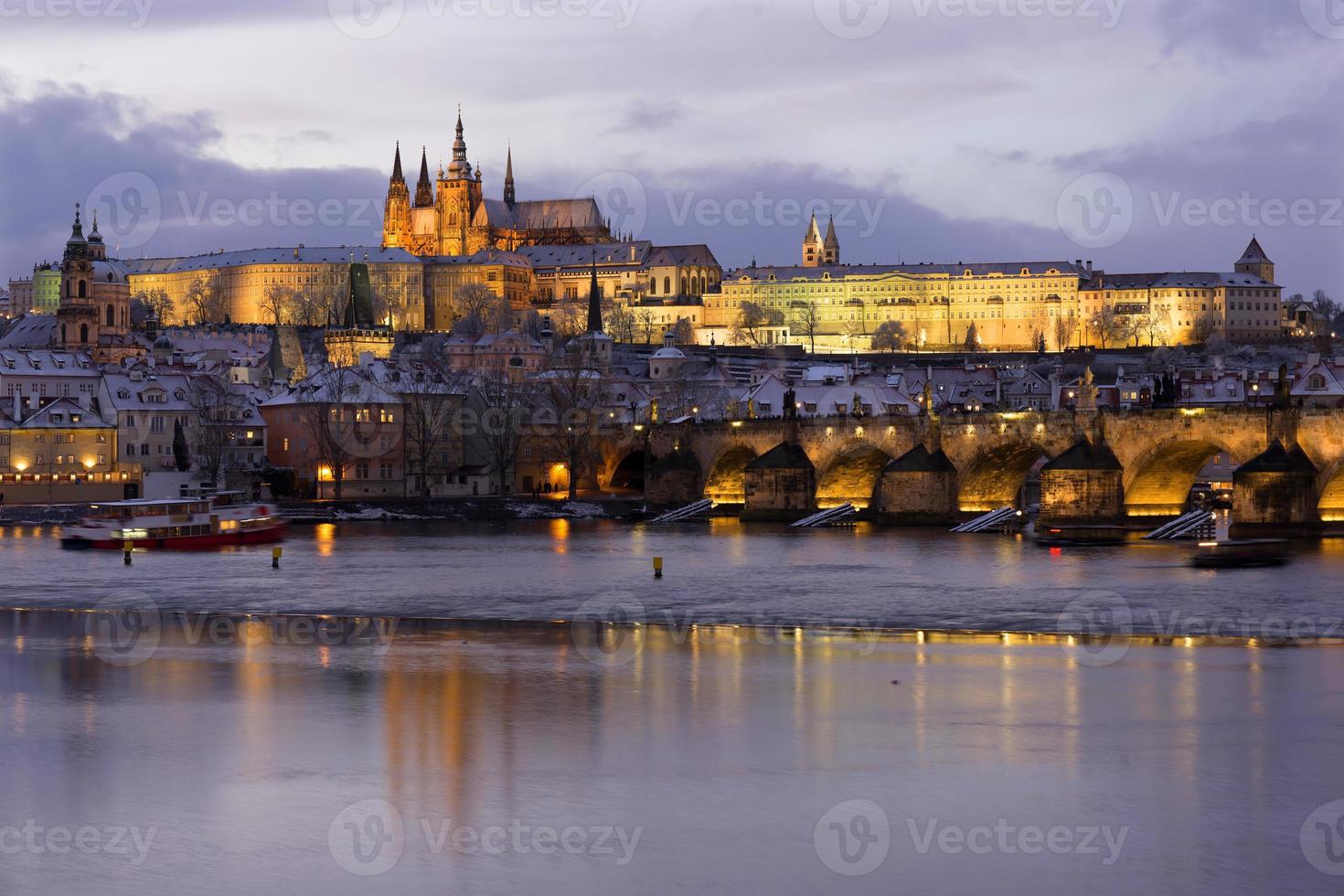 notte colorata natale innevato praga città minore con castello gotico e ponte carlo, repubblica ceca foto