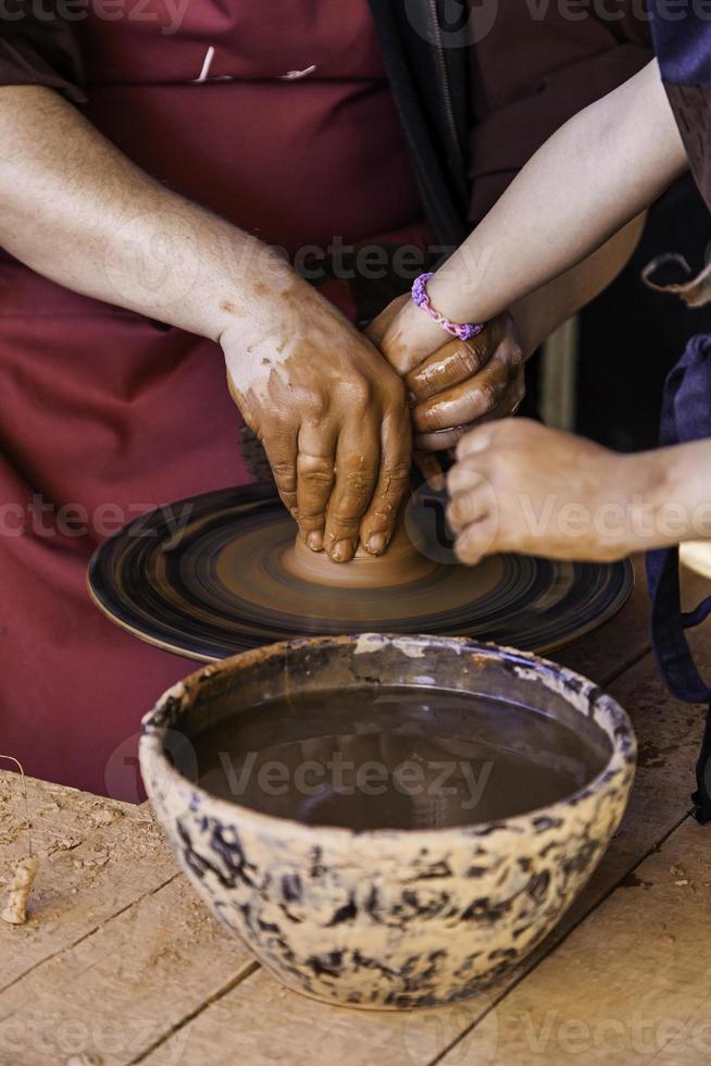 mani di un vasaio che forma argilla foto