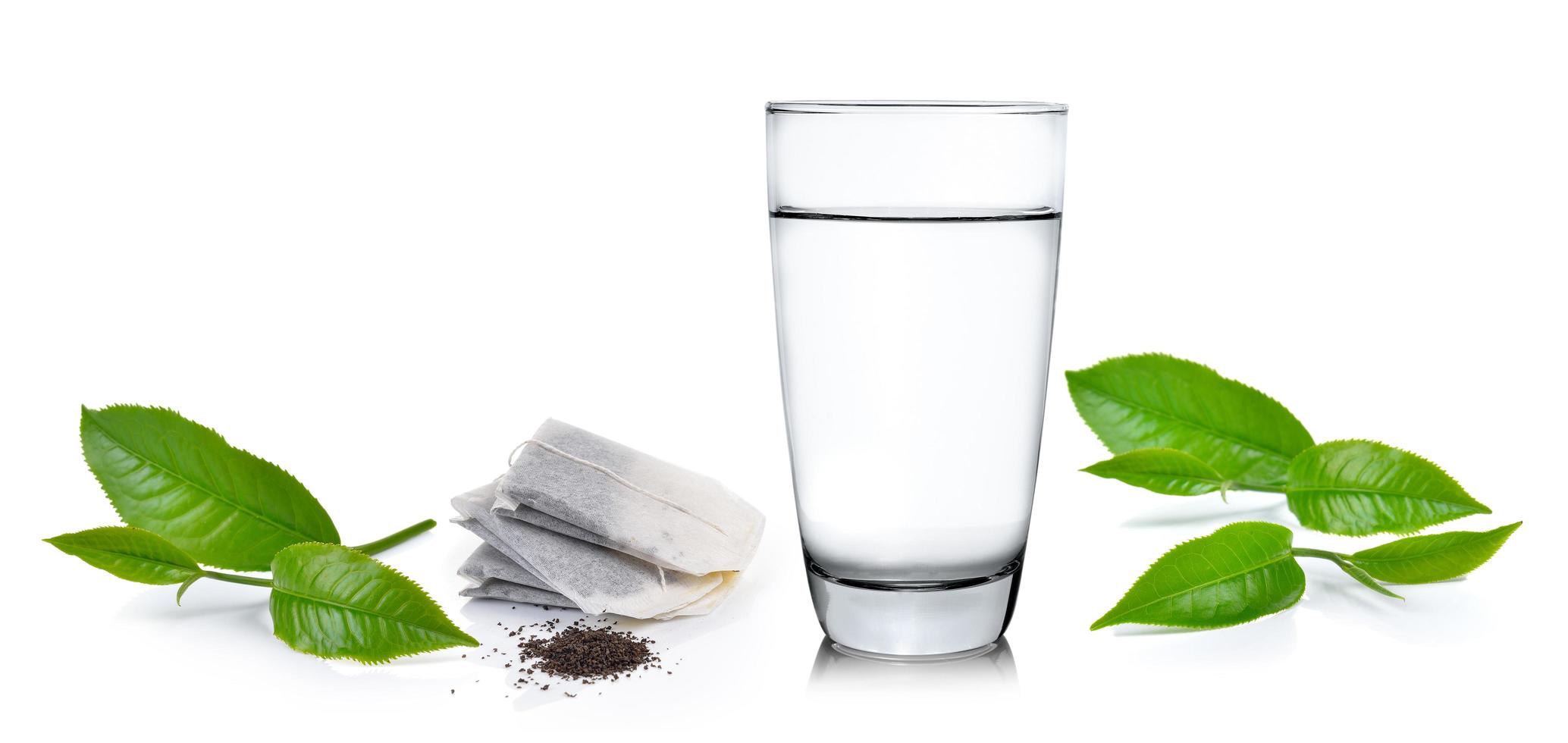 bicchiere d'acqua e foglie di tè isolate su sfondo bianco foto