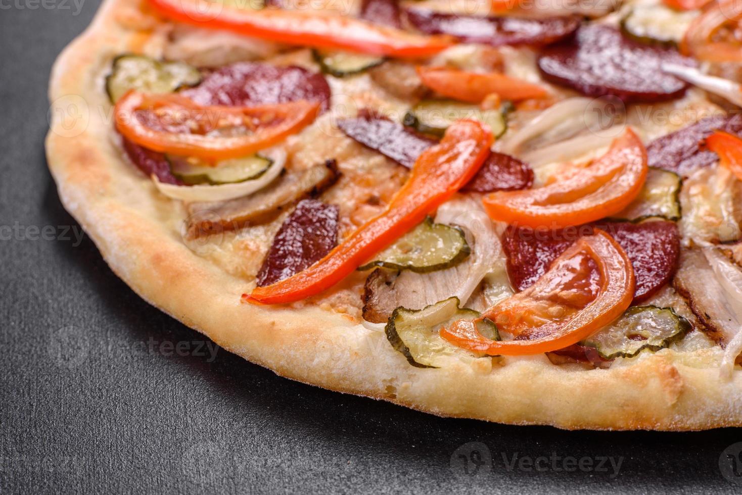 pizza fresca e deliziosa fatta in un forno a focolare con salsiccia, pepe e pomodori foto