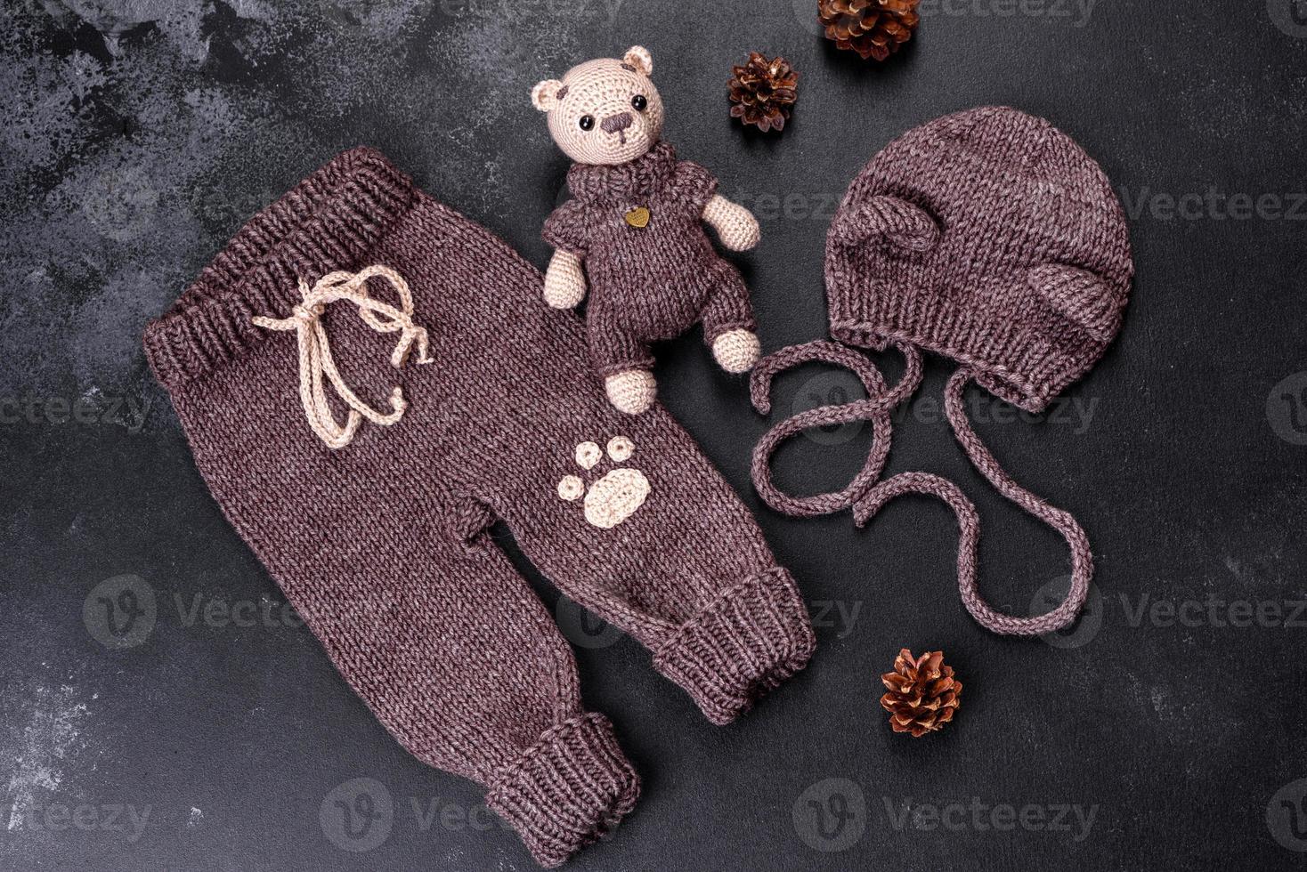 orso giocattolo legato da fili di lana su uno sfondo scuro foto