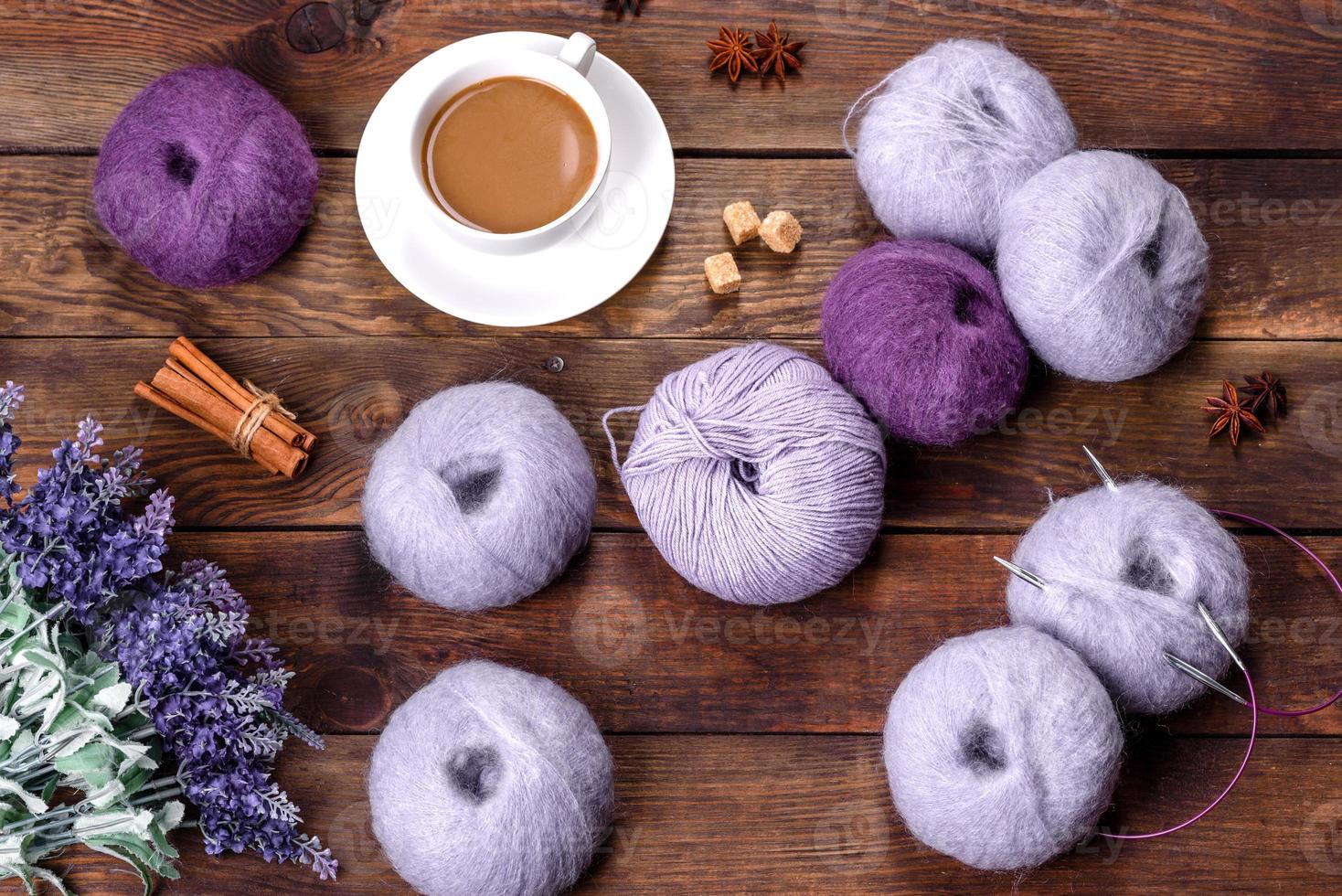 grovigli di fili di lana e raggi con una tazza di caffè e zucchero su uno sfondo di legno foto