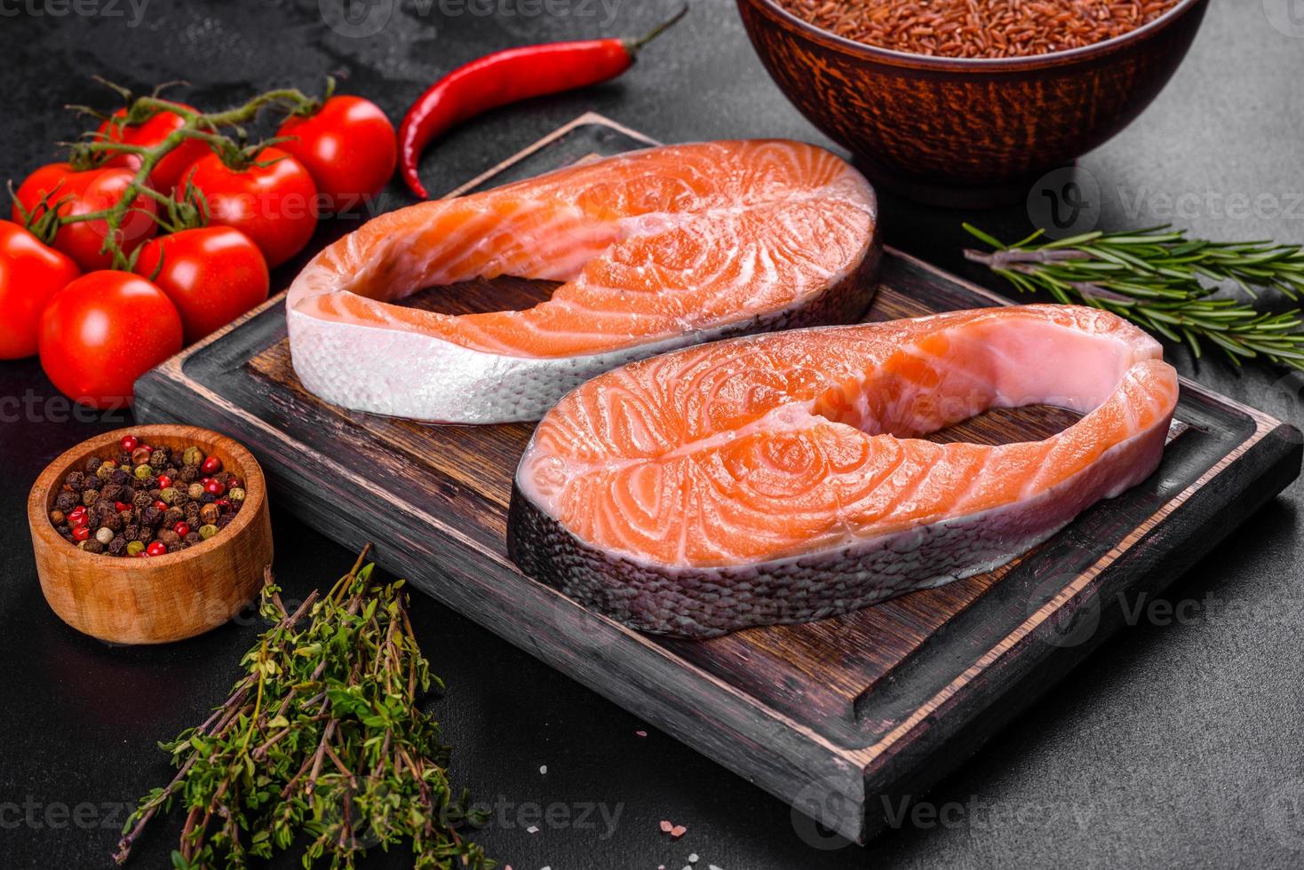 trancio di salmone crudo fresco con spezie ed erbe preparato per la cottura alla griglia foto