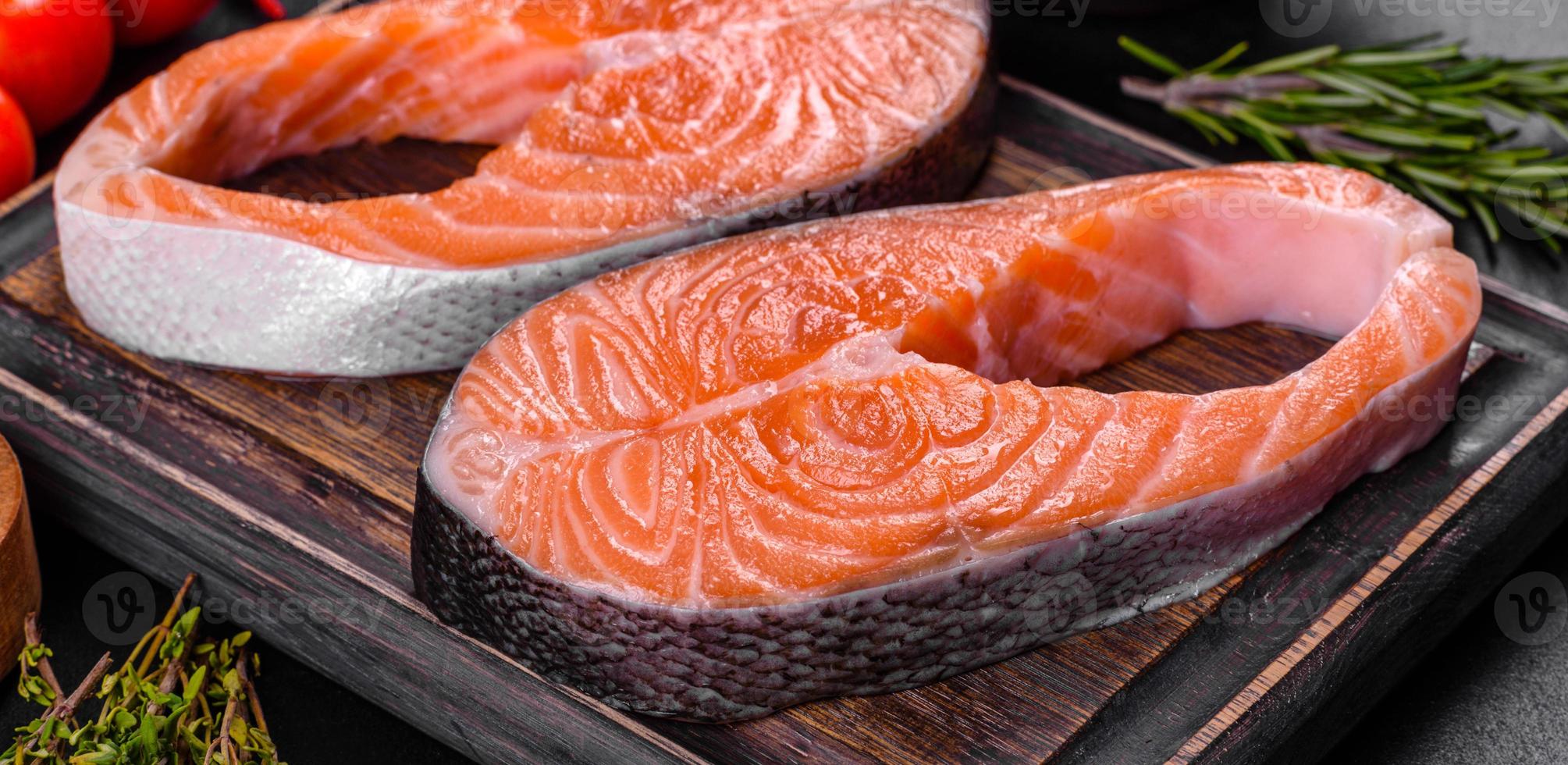 trancio di salmone crudo fresco con spezie ed erbe preparato per la cottura alla griglia foto