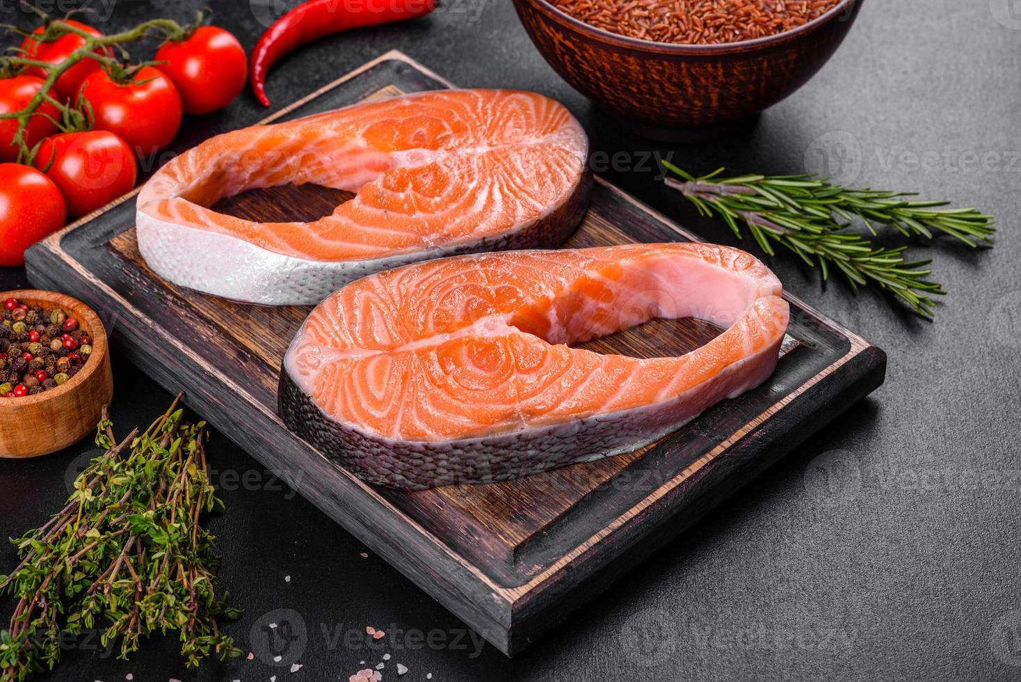 trancio di salmone crudo fresco con spezie ed erbe preparato per la cottura alla griglia foto