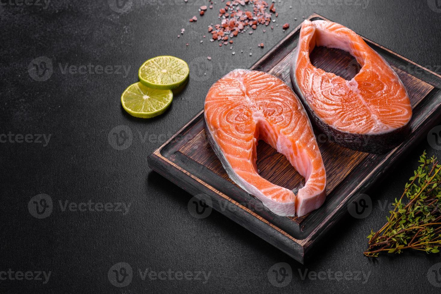 trancio di salmone crudo fresco con spezie ed erbe preparato per la cottura alla griglia foto