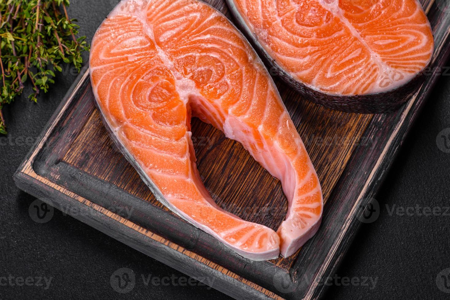 trancio di salmone crudo fresco con spezie ed erbe preparato per la cottura alla griglia foto