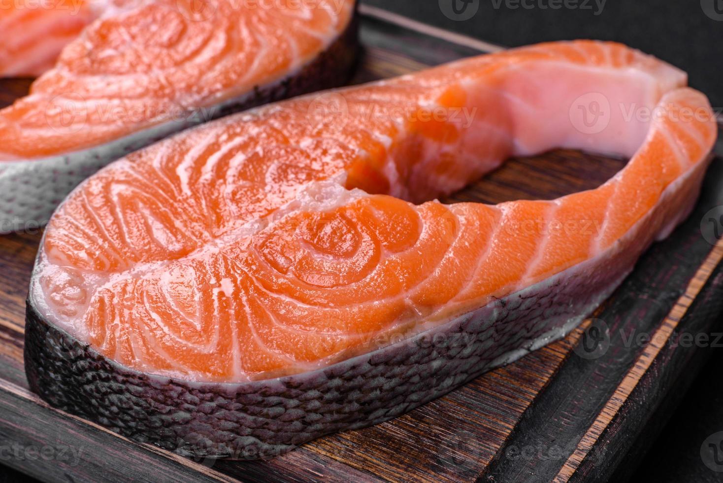 trancio di salmone crudo fresco con spezie ed erbe preparato per la cottura alla griglia foto