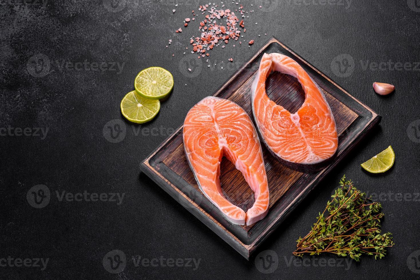 trancio di salmone crudo fresco con spezie ed erbe preparato per la cottura alla griglia foto