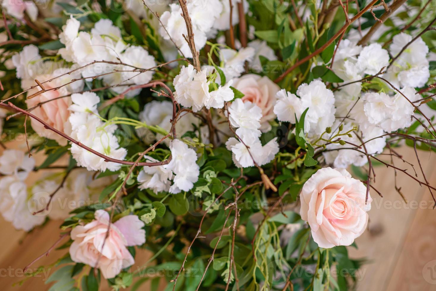 decorazioni di rami con bellissimi fiori rosa e bianchi nel cesto sullo sfondo di un muro di mattoni bianchi foto