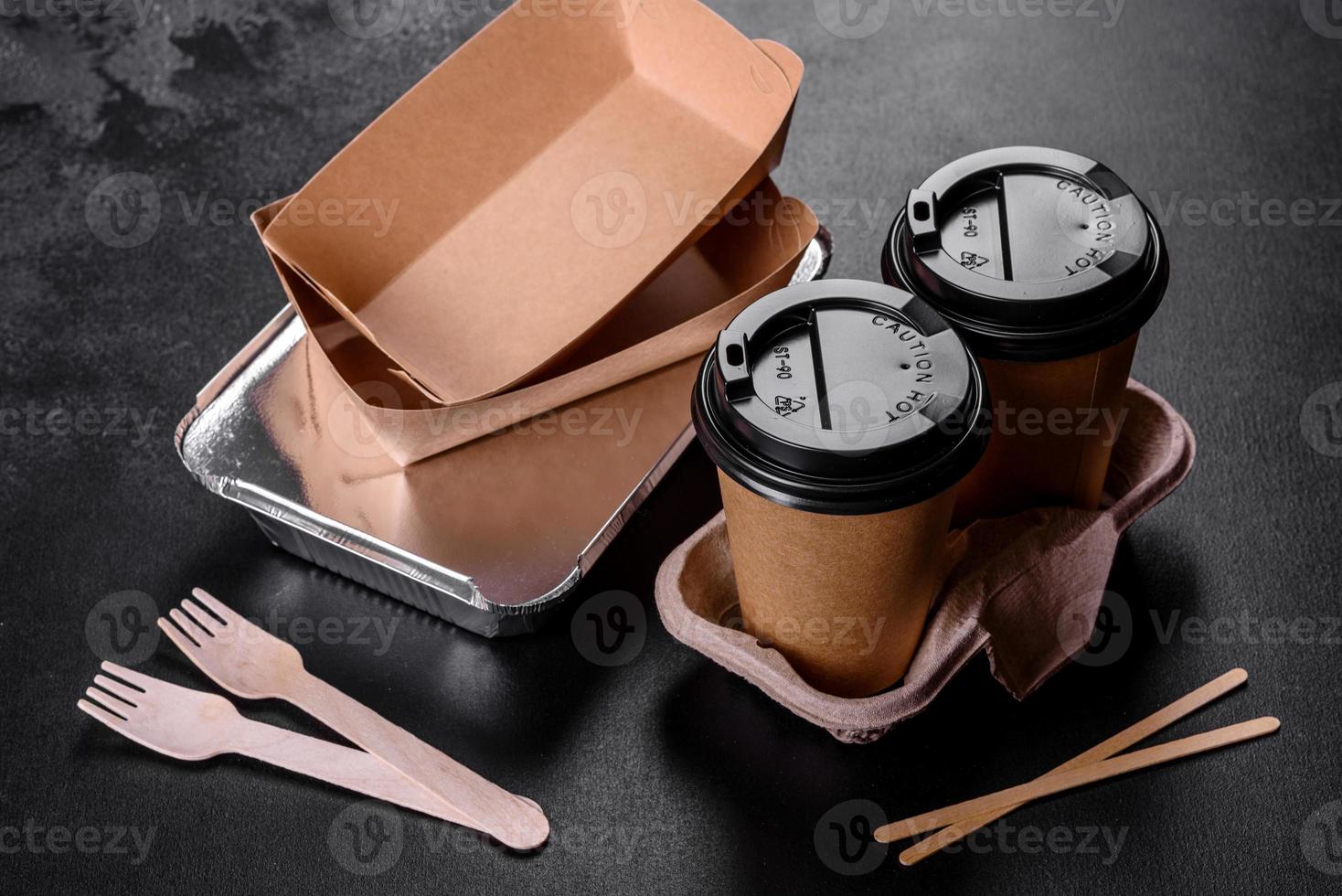 piatti usa e getta realizzati in cartone marrone ecologico su sfondo scuro foto