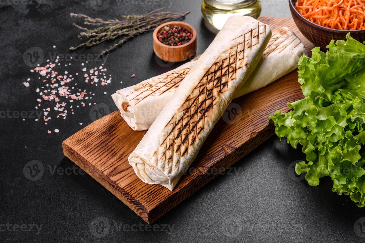 delizioso shawarma fresco con carne e verdure su un tavolo di cemento scuro foto