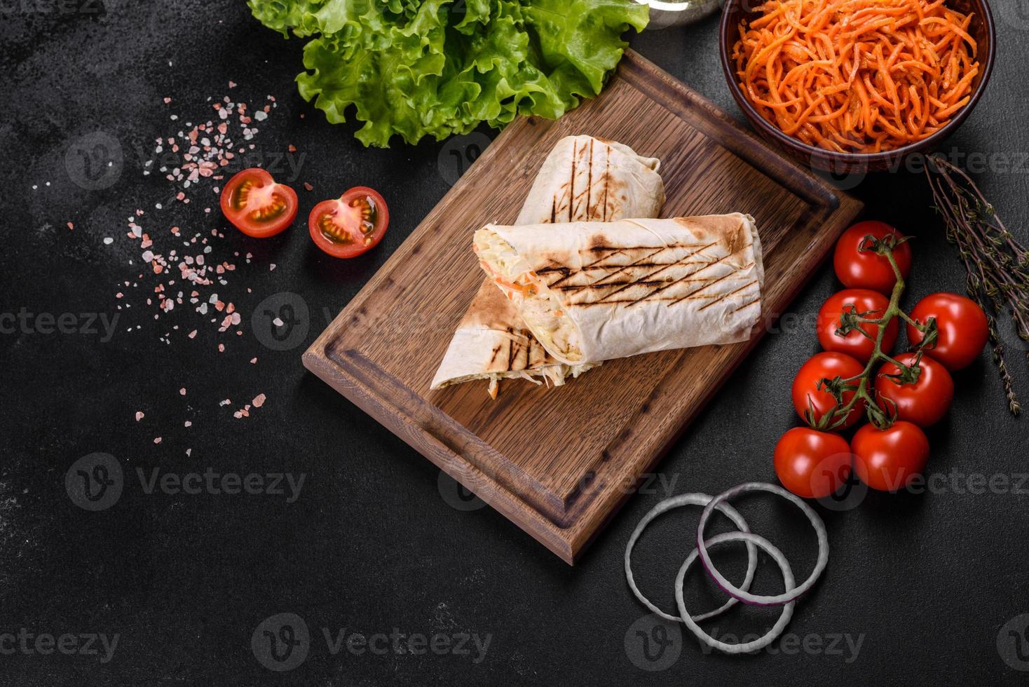 delizioso shawarma fresco con carne e verdure su un tavolo di cemento scuro foto