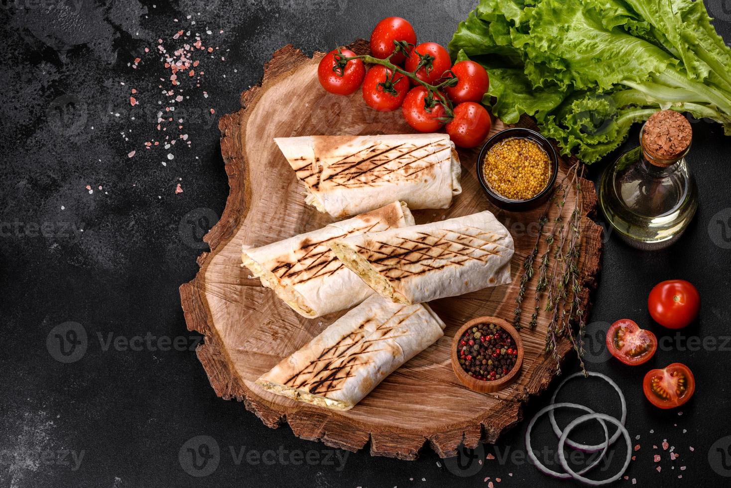 delizioso shawarma fresco con carne e verdure su un tavolo di cemento scuro foto