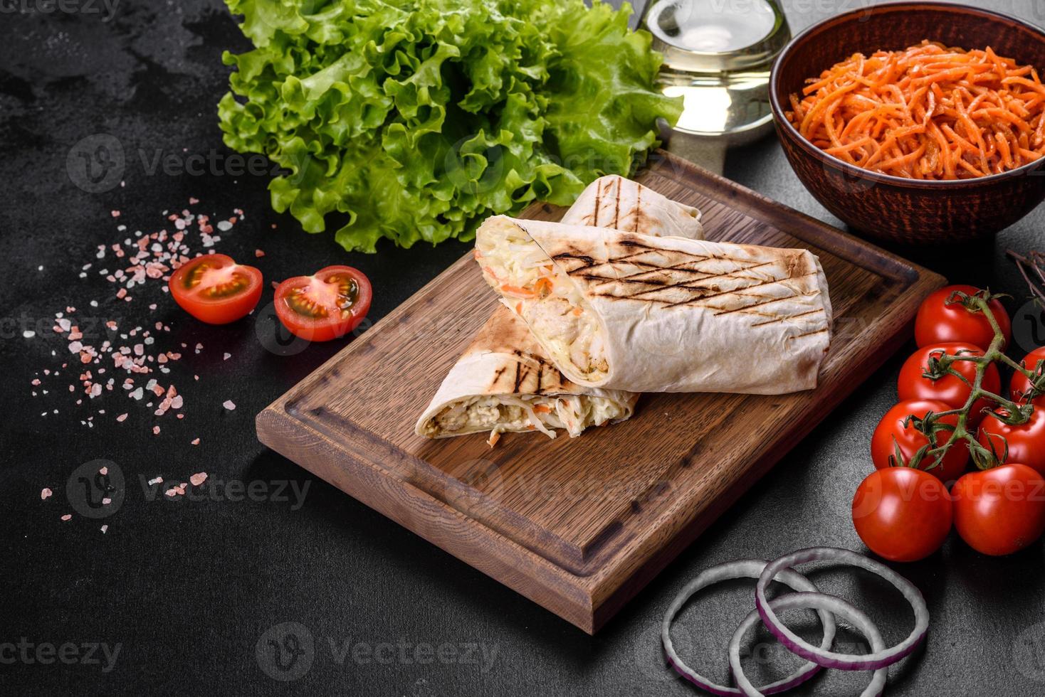 delizioso shawarma fresco con carne e verdure su un tavolo di cemento scuro foto