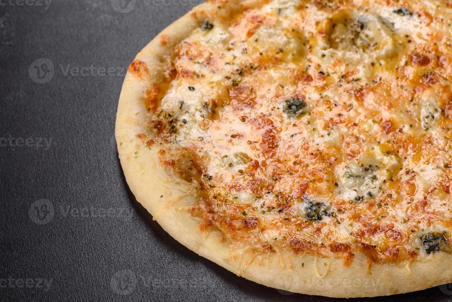 gustosa pizza fresca al forno con pomodori, formaggio e funghi su uno sfondo di cemento scuro foto