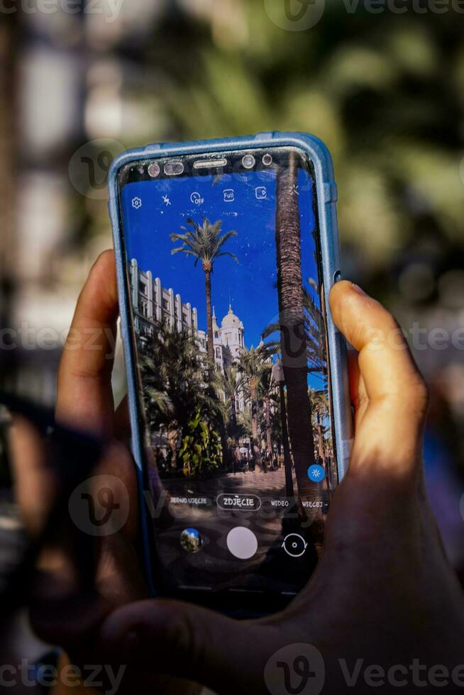 mobile Telefono nel mani mentre assunzione foto spiegato nel alicante, Spagna