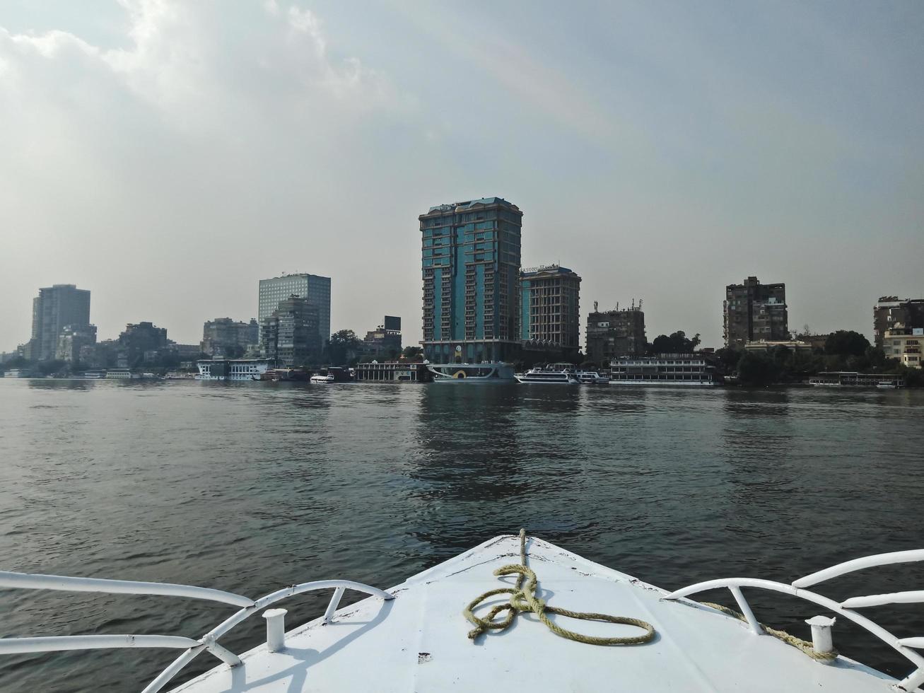vista da una barca. grandi edifici sulla costa del fiume nilo. città del cairo, egitto foto