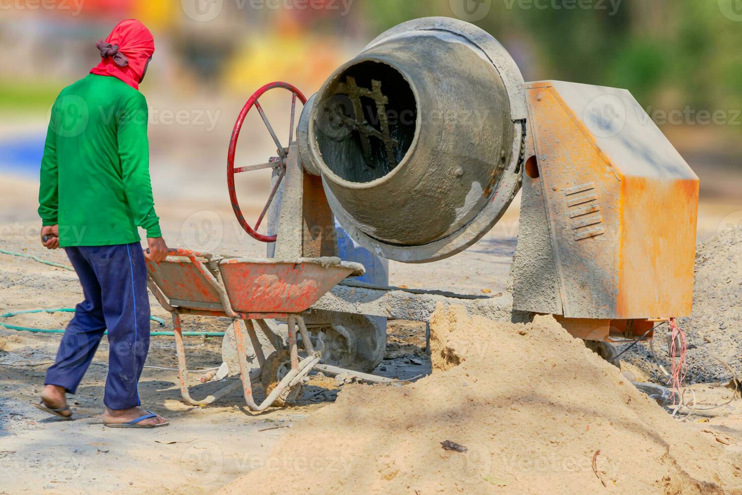 costruzione lavoro duro e faticoso scarica cemento misto con un' carriola. foto