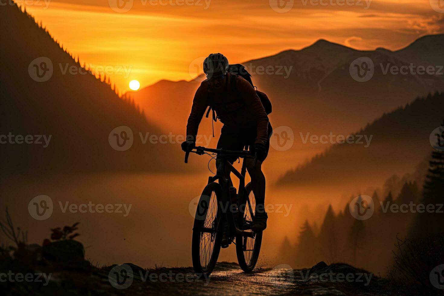 silhouette di un' viaggiatore su un' montagna bicicletta nel il arancia leggero di il crescente sole contro il fondale di un' montagna paesaggio foto