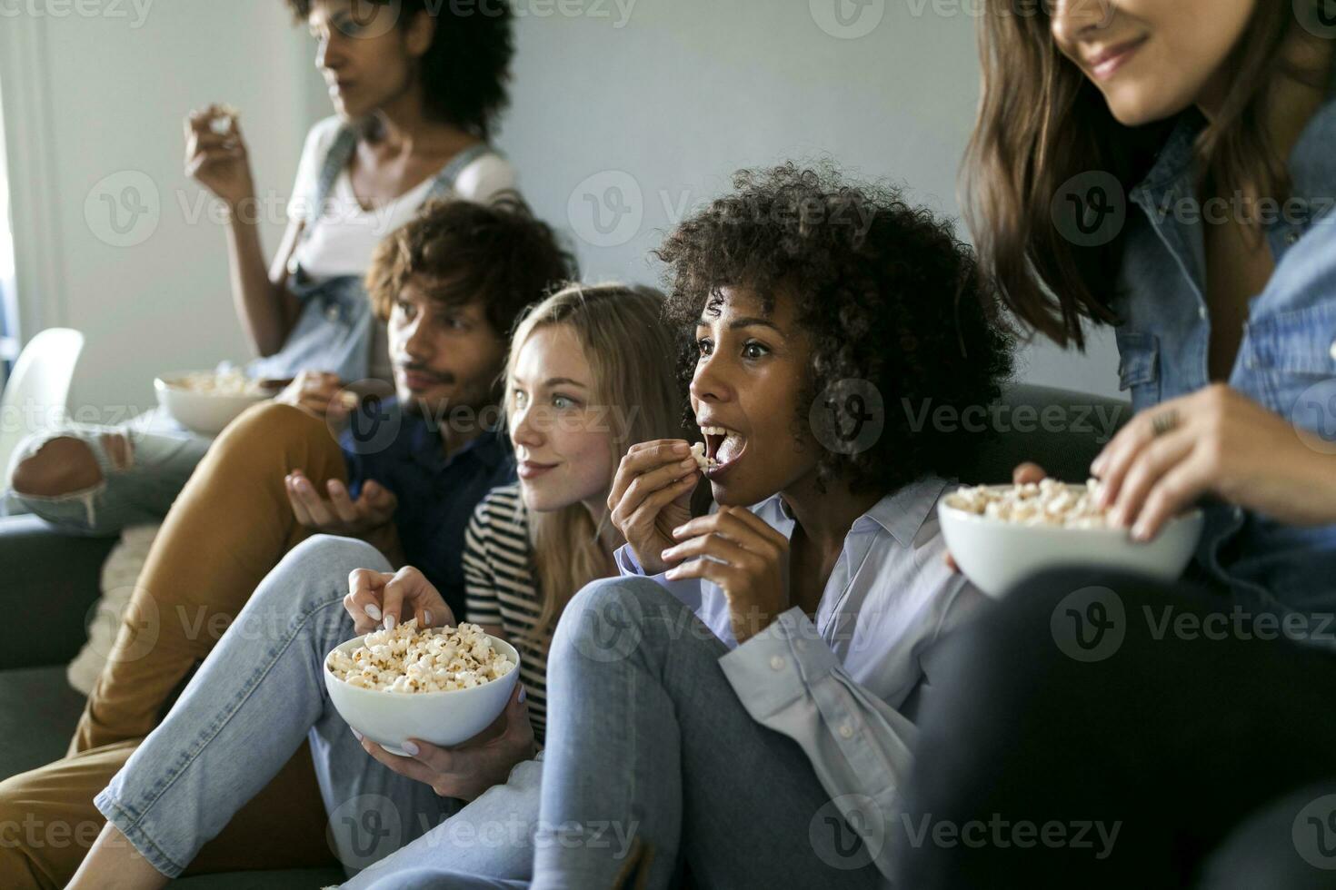 amici seduta su divano Guardando tv foto