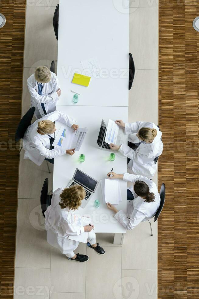 femmina medici lettura documenti nel un' incontro nel conferenza camera foto