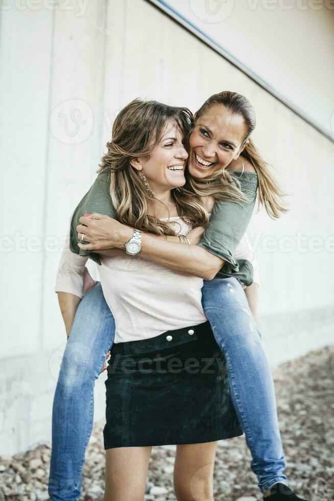 ridendo donna dando sua amico un' a cavalluccio cavalcata foto