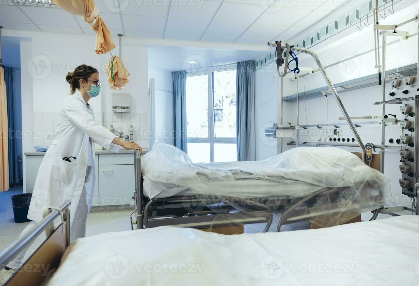 medico nel ospedale camera spingendo letti foto