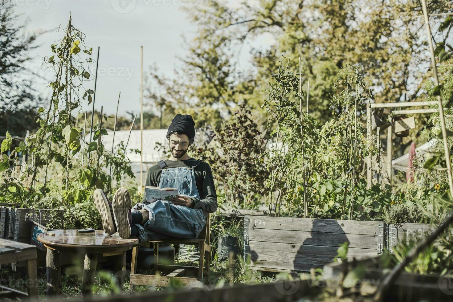 sorridente uomo lettura libro nel urbano giardino foto